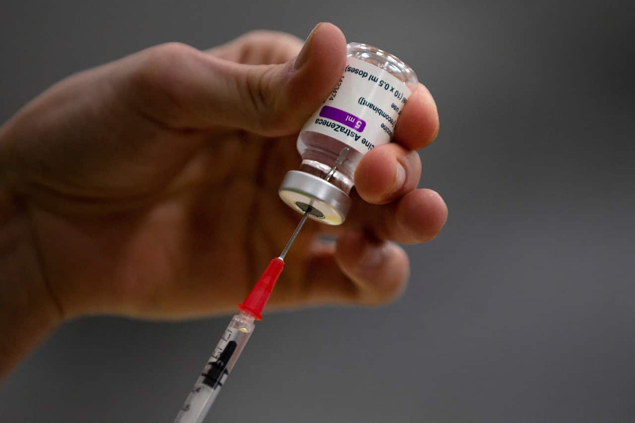 A syringe enters a vial of the AstraZeneca coronavirus vaccine.