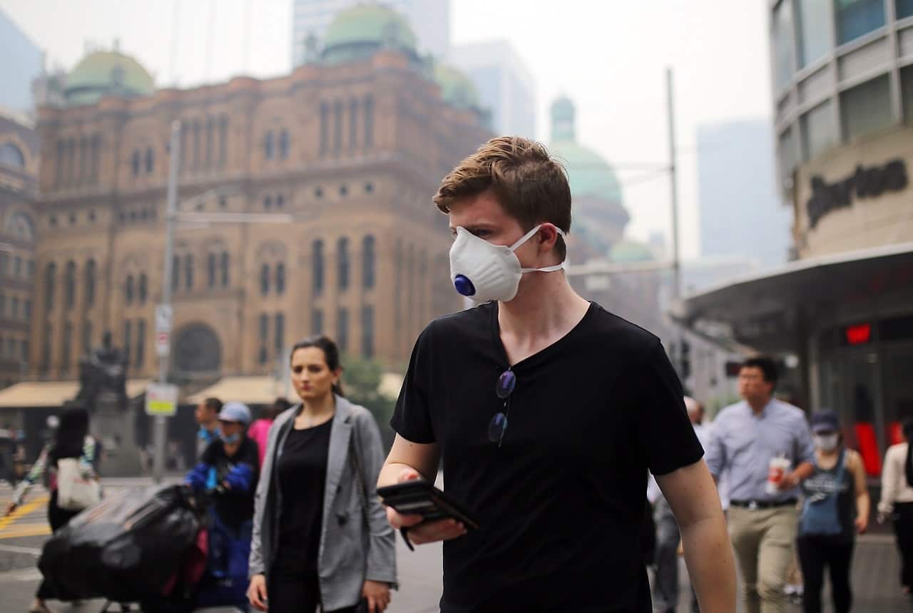 Pedestrians wear masks as smoke haze from bushfires hits Sydney.