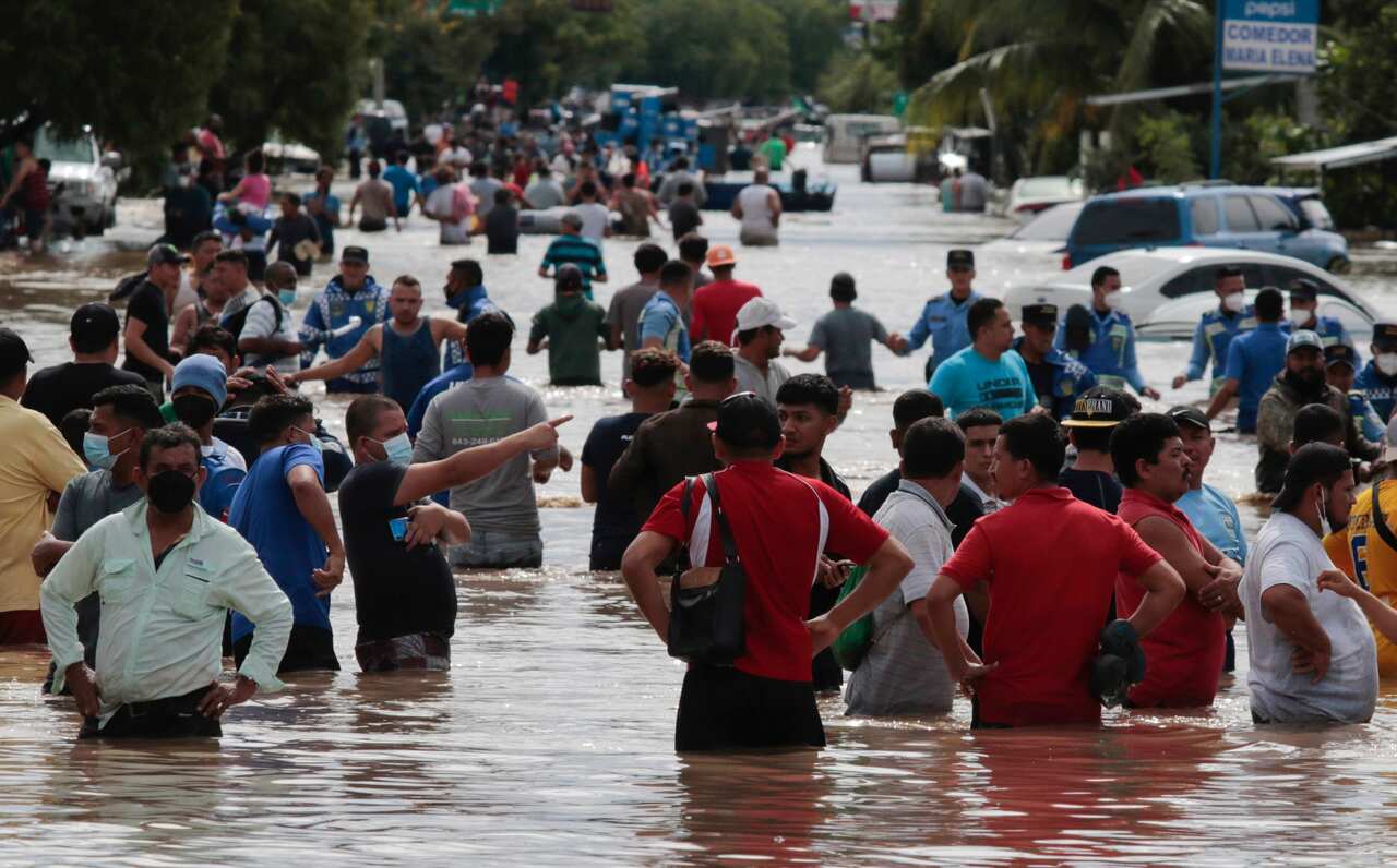 Residents wade through a flooded road in the aftermath of Hurricane Eta in Planeta, Honduras, on 5 November.