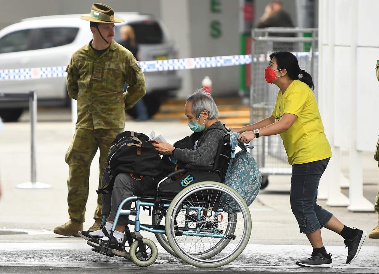 Returning overseas travellers at Sydney International Airport in Sydney are directed by army officers to go into quarantine. 