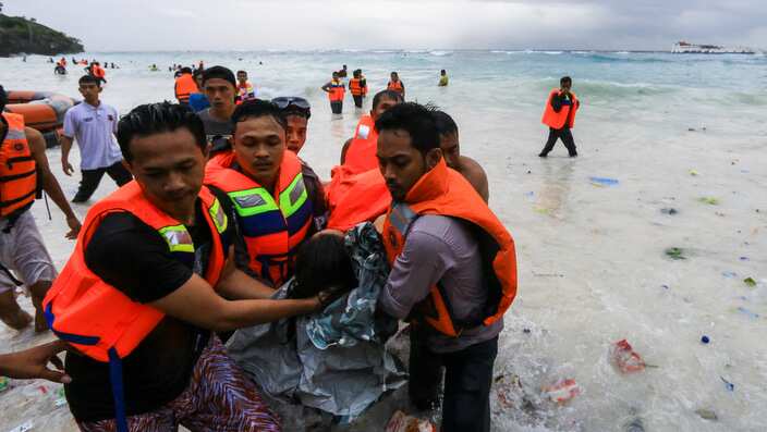 Indonesian rescuers evacuate a victim of a sinking ferry off the coast of Selayar island, in South Sulawesi, Indonesia.