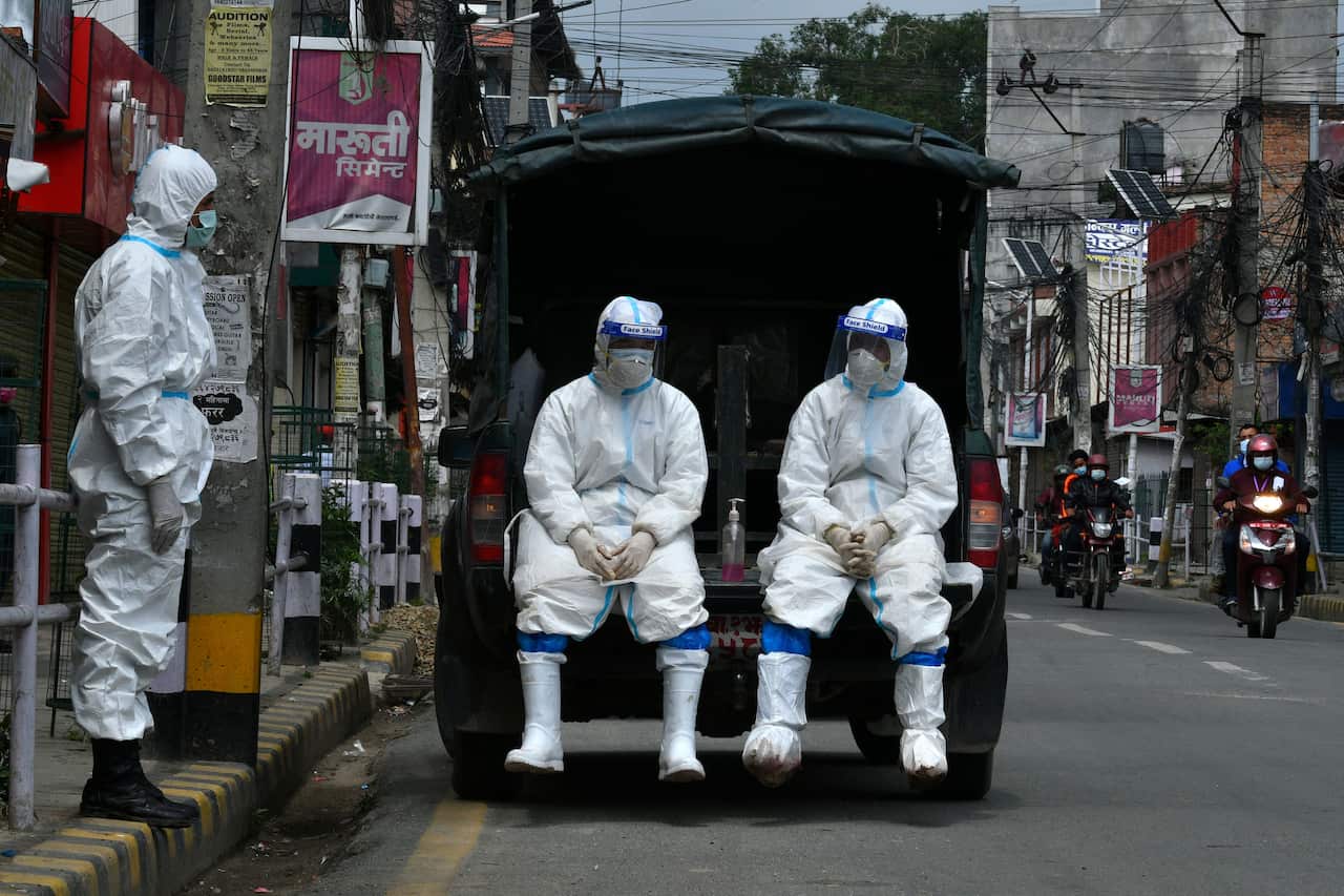 Nepal army personnel wait to transport the body of a person who died from COVID-19 to a crematorium in Kathmandu on 5 May, 2021. 