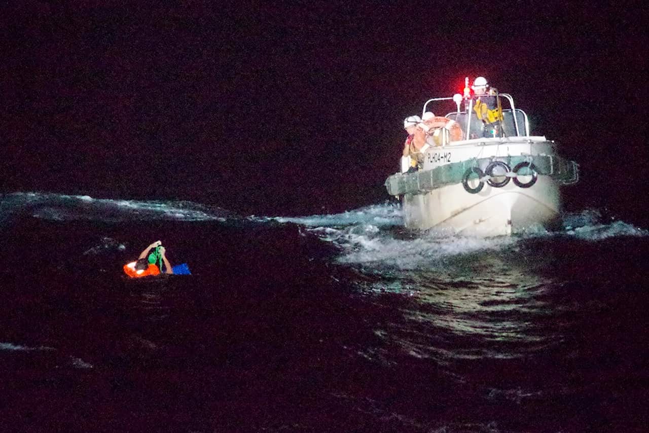 A Filipino crewmember of a Panamanian cargo ship is rescued by Japanese Coast Guard members in the waters off the Amami Oshima