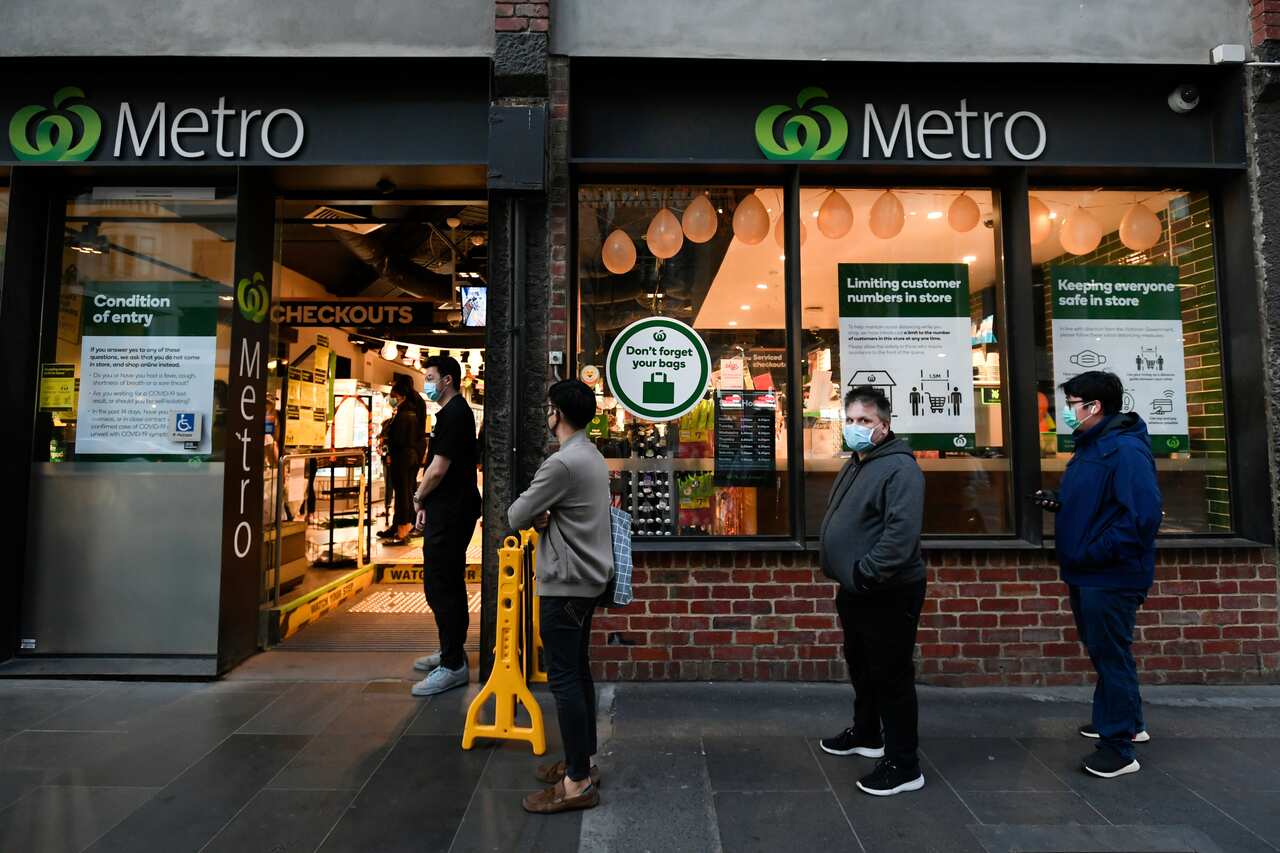 People line up to enter a supermarket hours in Melbourne.