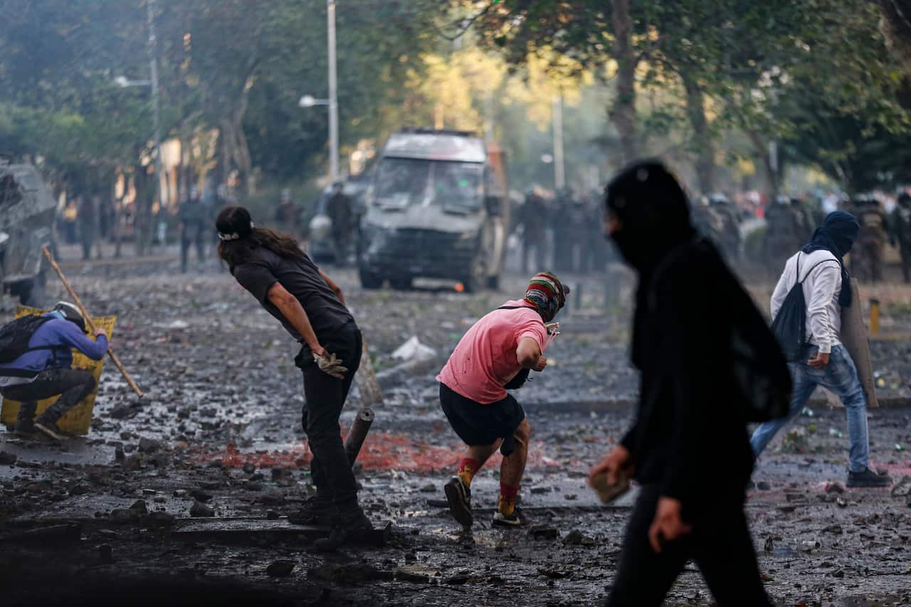 Anti-government protesters face off with riot police in the streets.