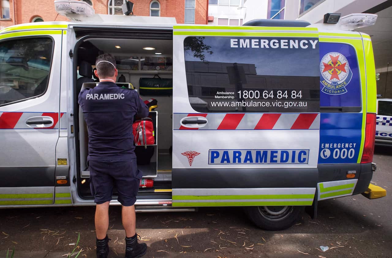 A file image shows paramedics by an ambulance outside St. Vincent hospital in Melbourne, Tuesday, 11 January, 2022. 