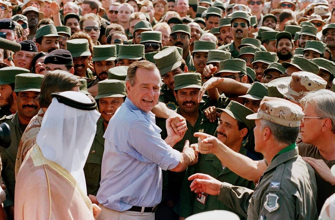 1990: President George Bush is greeted by Saudi troops and others as he arrives in Dhahran, Saudi Arabia, for a Thanksgiving visit.