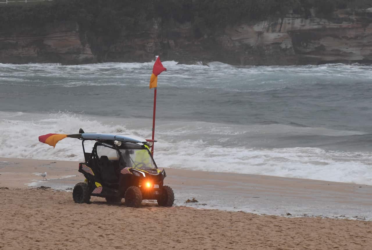 A lifeguard is seen during wet weather in Coogee, Sydney, Friday, February 7, 2020. Heavy rain is drenching large swathes of eastern NSW, forcing road closures and sparking concerns about the risk of flash flooding. (AAP Image/Peter Rae) NO ARCHIVING