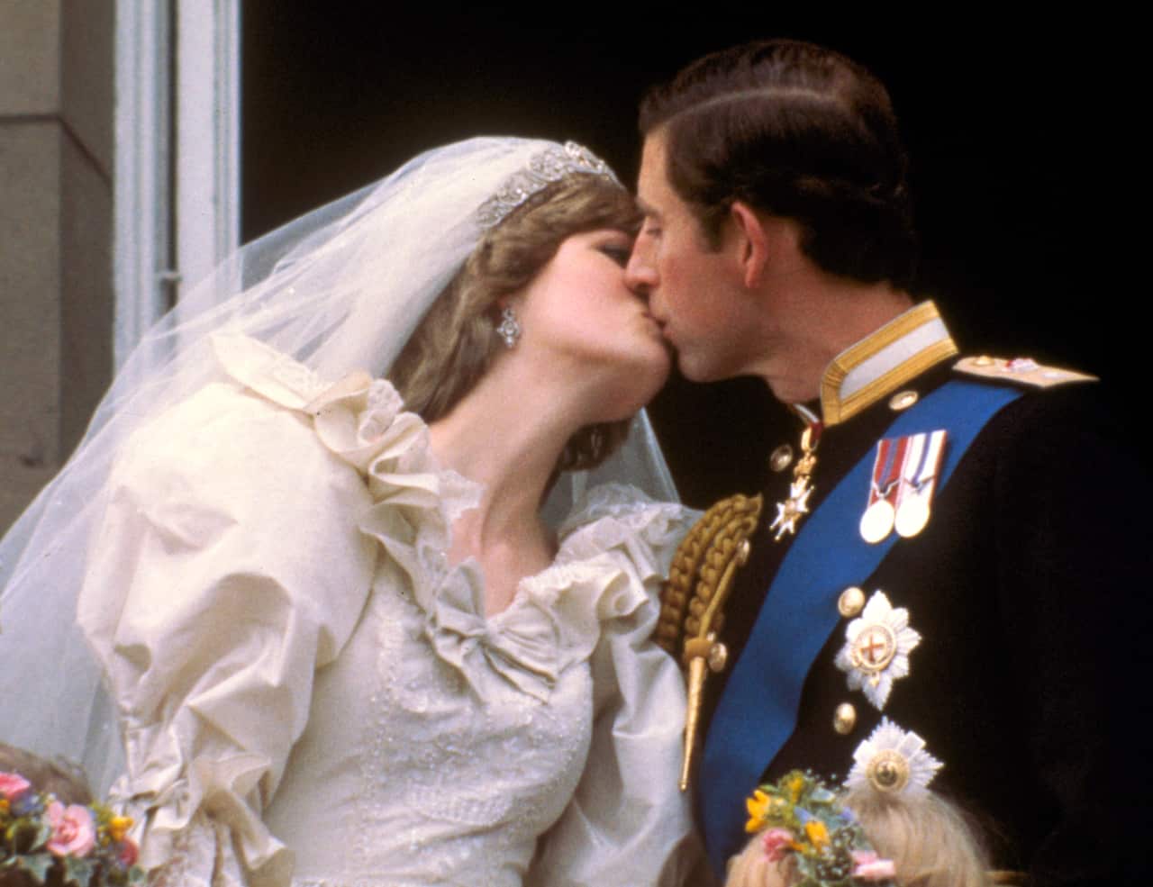 Princess Diana and Prince Charles kiss on the balcony of Buckingham Palace following their 1981 marriage.