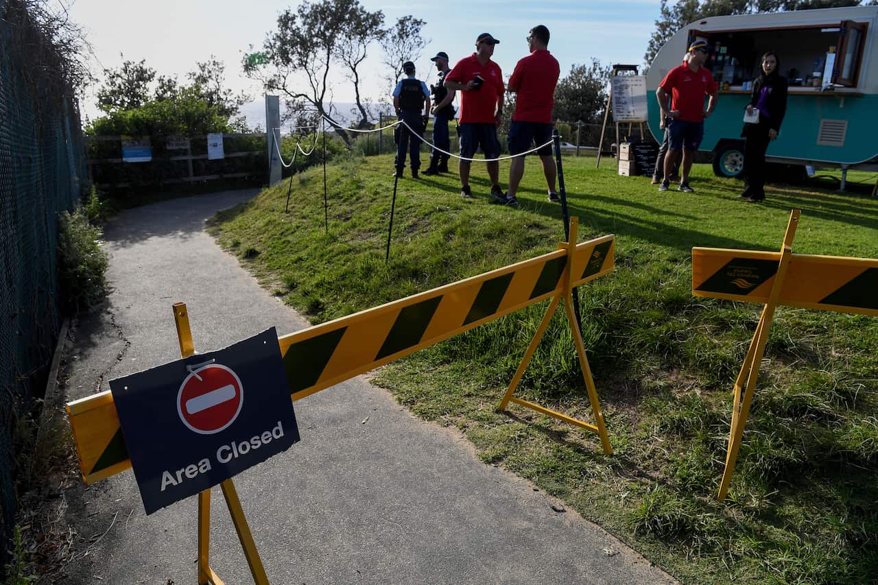 A area closed sign and a barrier blocking access to the beach is seen at Little Bay Beach in Sydney, 17 February.