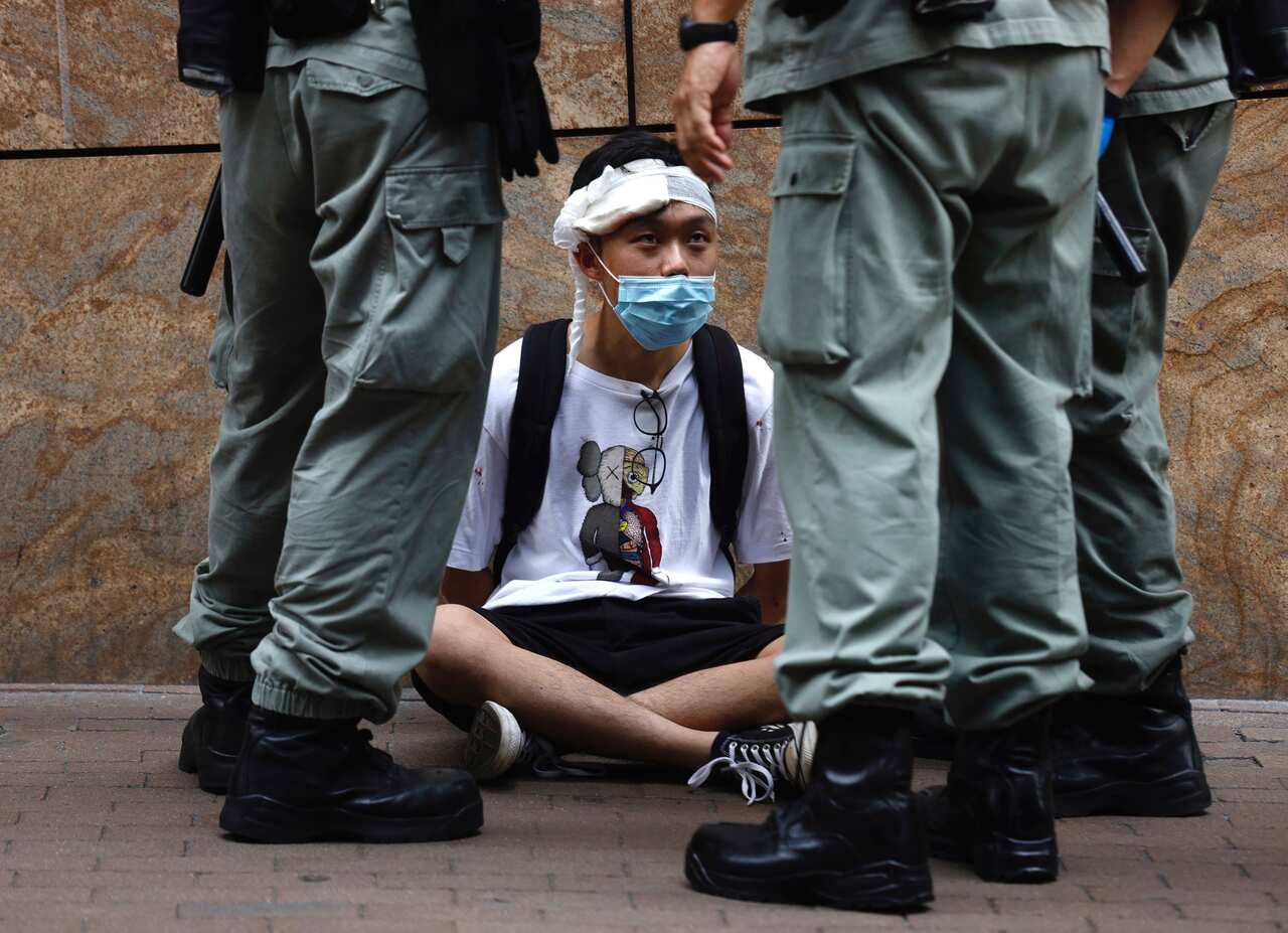 Riot police guard arrested protester.