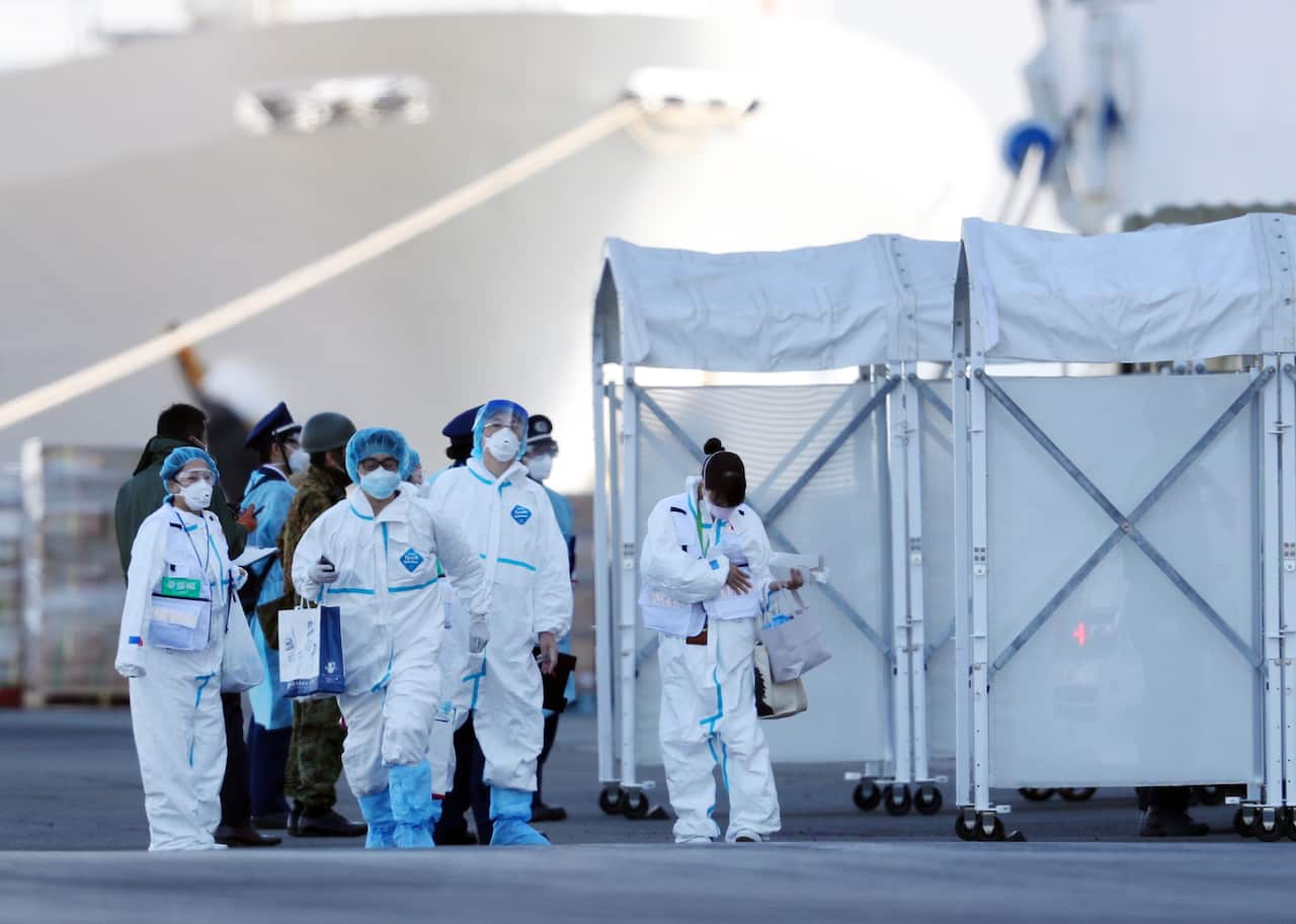 Staff members wearing protective gear prepare to enter the Diamond Princess cruise ship in Yokohama,  Japan, 10 February 2020. 