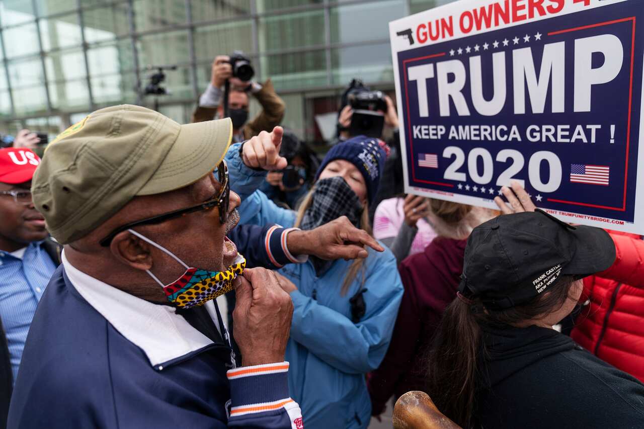 Trump supporters, rear, argue with a counter protestor at left during demonstrations in Michigan. 