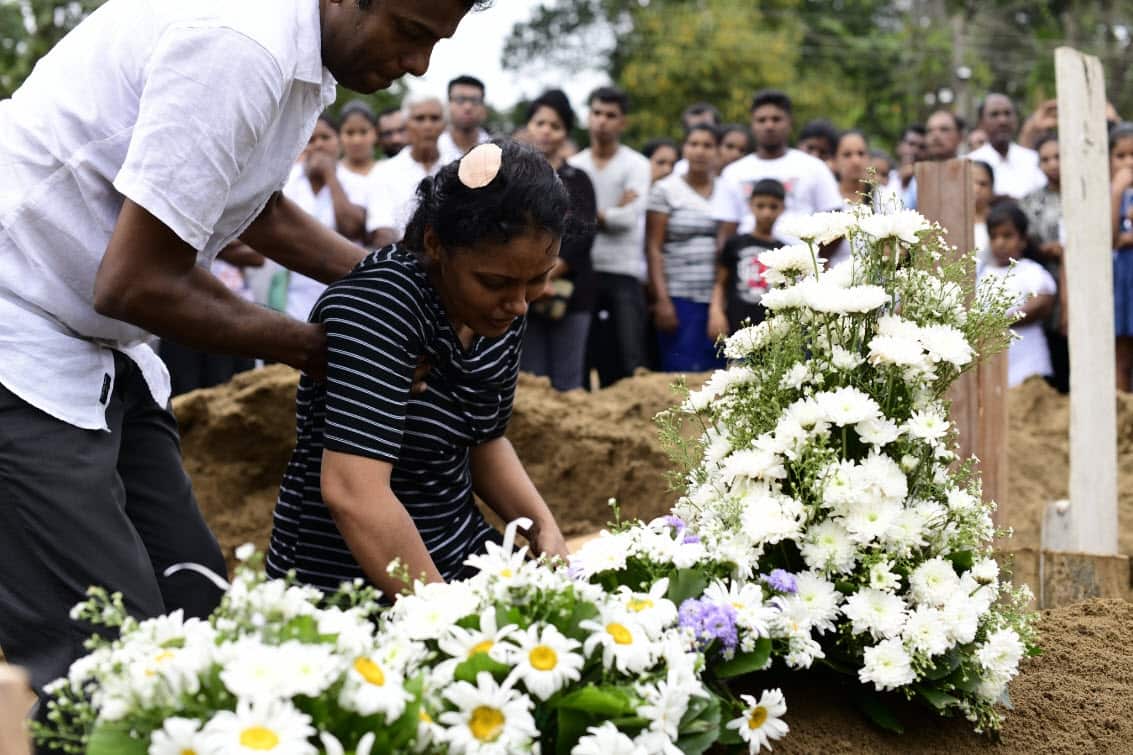 A woman grieves at the grave after a funeral for a person killed in the Easter Sunday attack on St. Sebastian's Church on April 25, 2019 in Negombo, Sri Lanka (AAP)