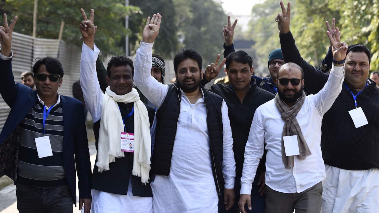 AAP candidate Amanatullah Khan from Okhla constituency shows the victory sign along with his supporters as his party leads in Delhi Assembly election.