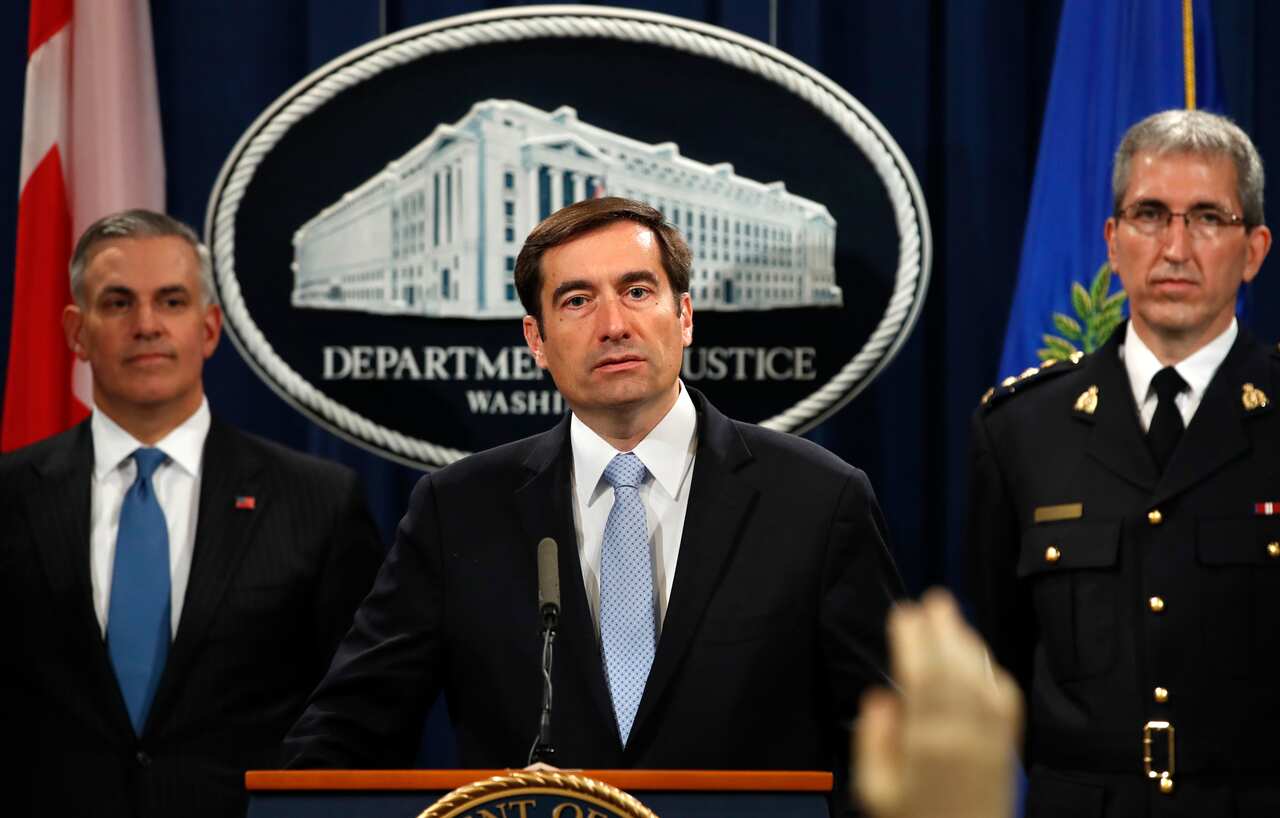 Assistant Attorney General John Demers answers questions during a news conference.