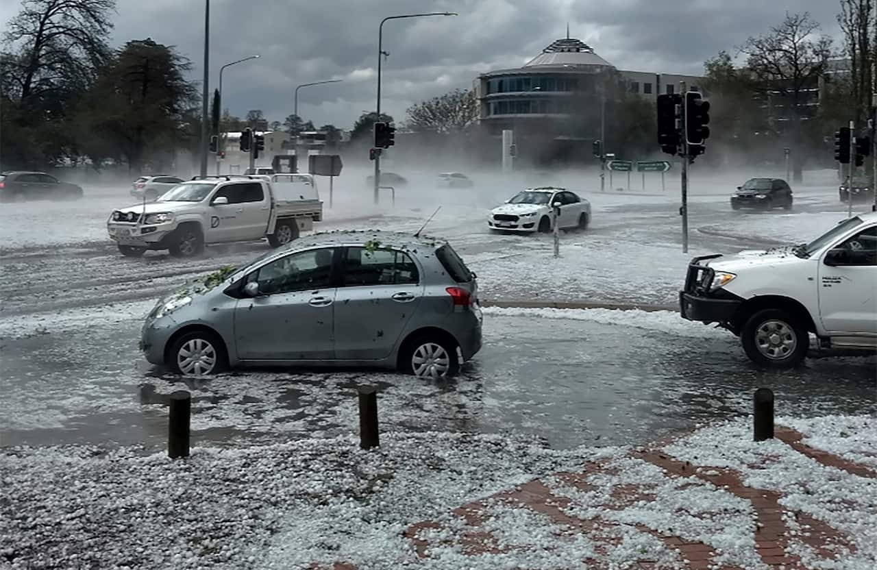 Hail covers vehicles in an intersection in Canberra.