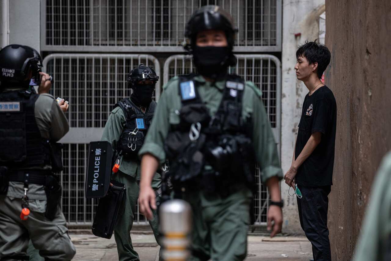 A man is detained and searched by police during a rally against the national security law in Hong Kong