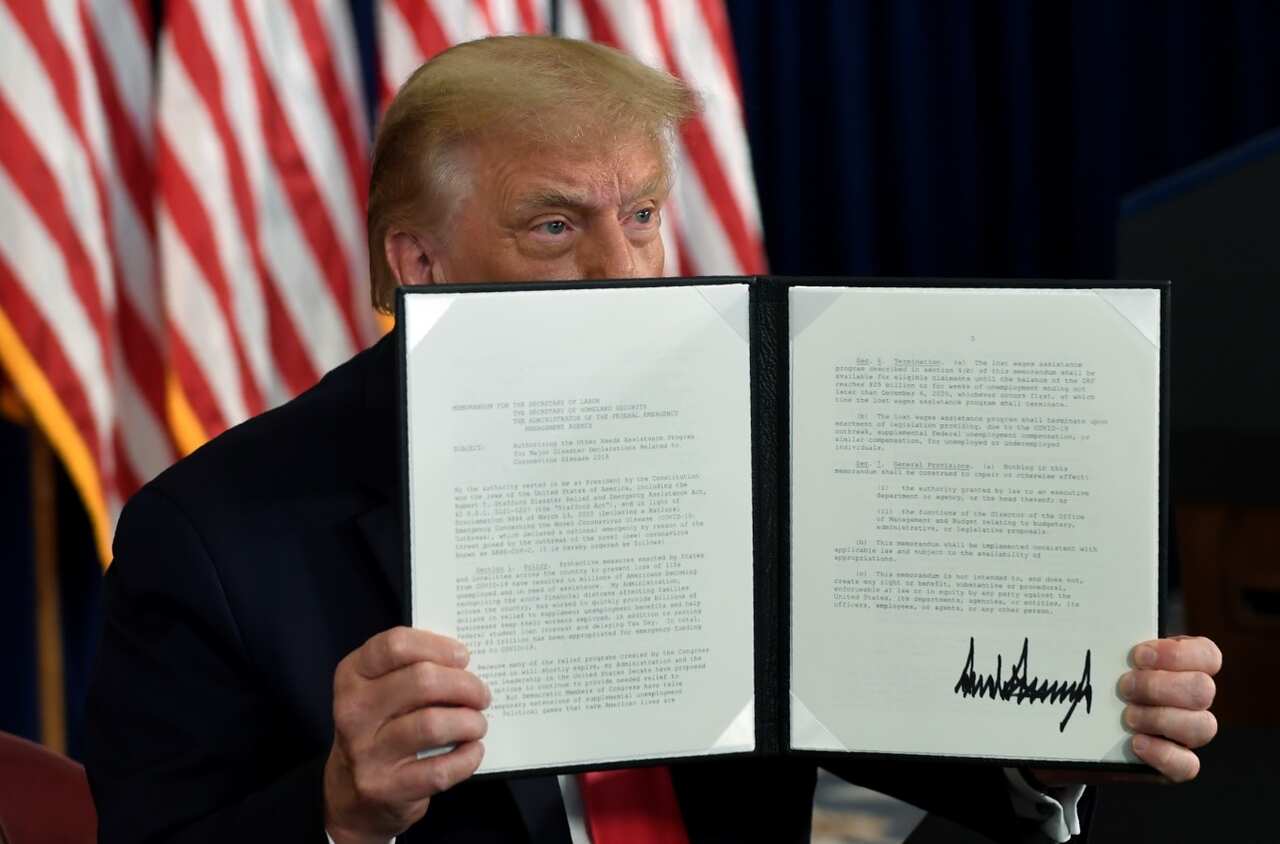 President Donald Trump signs an executive order during a news conference at the Trump National Golf Club in Bedminster, NJ Saturday, Aug. 8, 2020.