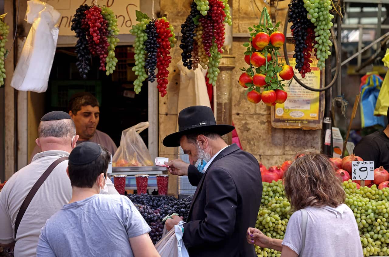 People shop at a market in Jerusalem in preparation for Rosh Hashanah, the Jewish New Year, on 6 September, 2021.