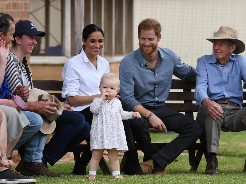 Meghan and Harry smile at toddler Ruby Carroll at a Dubbo farm.