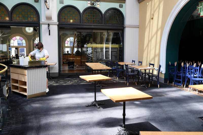 Staff prepare empty cafe seating areas for reopening, at the QVB in Sydney, Saturday, 9 October, 2021.