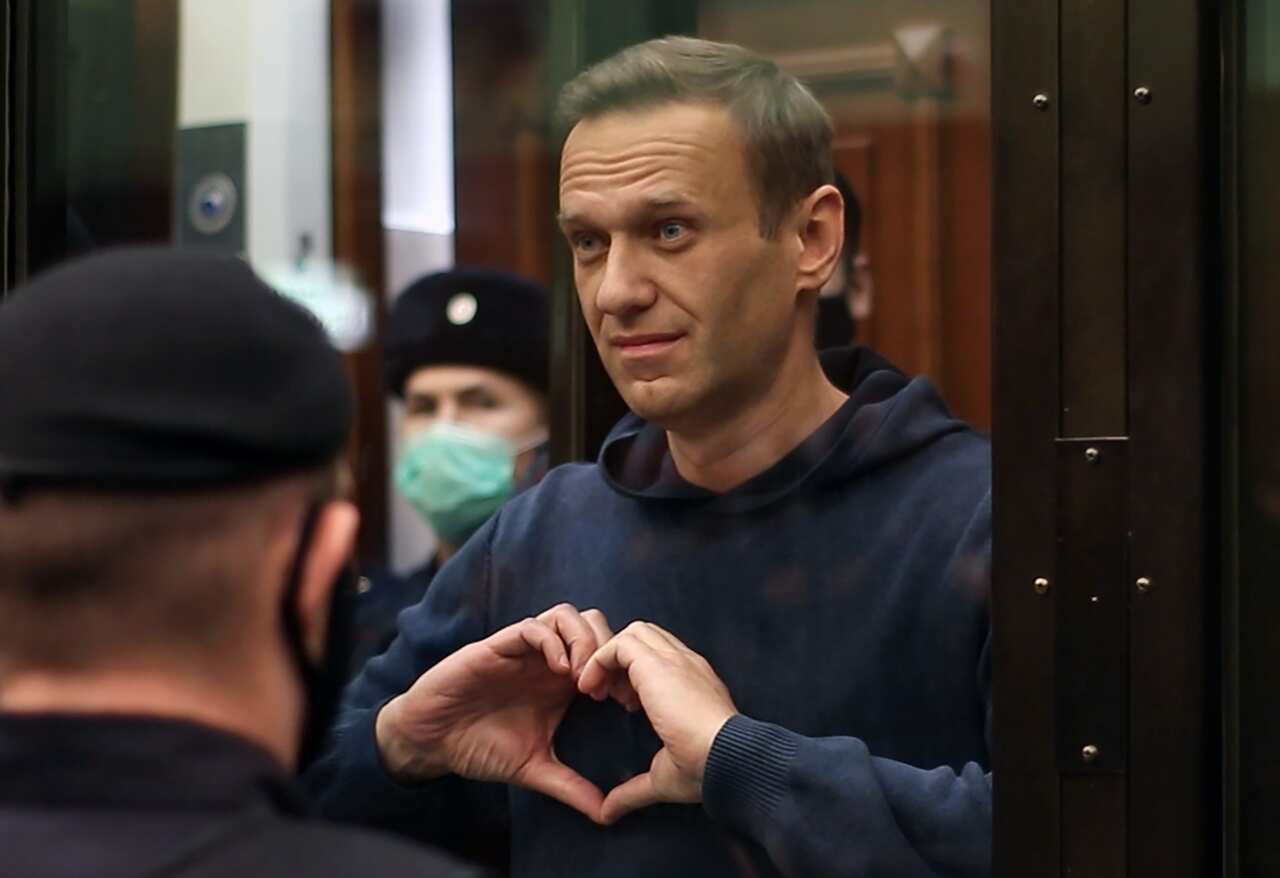 Alexei Navalny makes a heart gesture during a hearing to convert his suspended sentence of three and a half years into a real jail term.