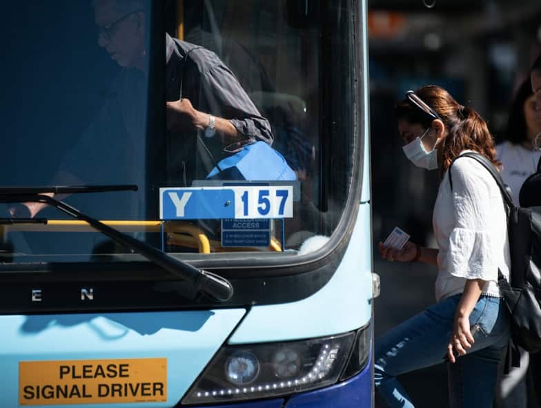 A woman gets on a bus in Sydney.