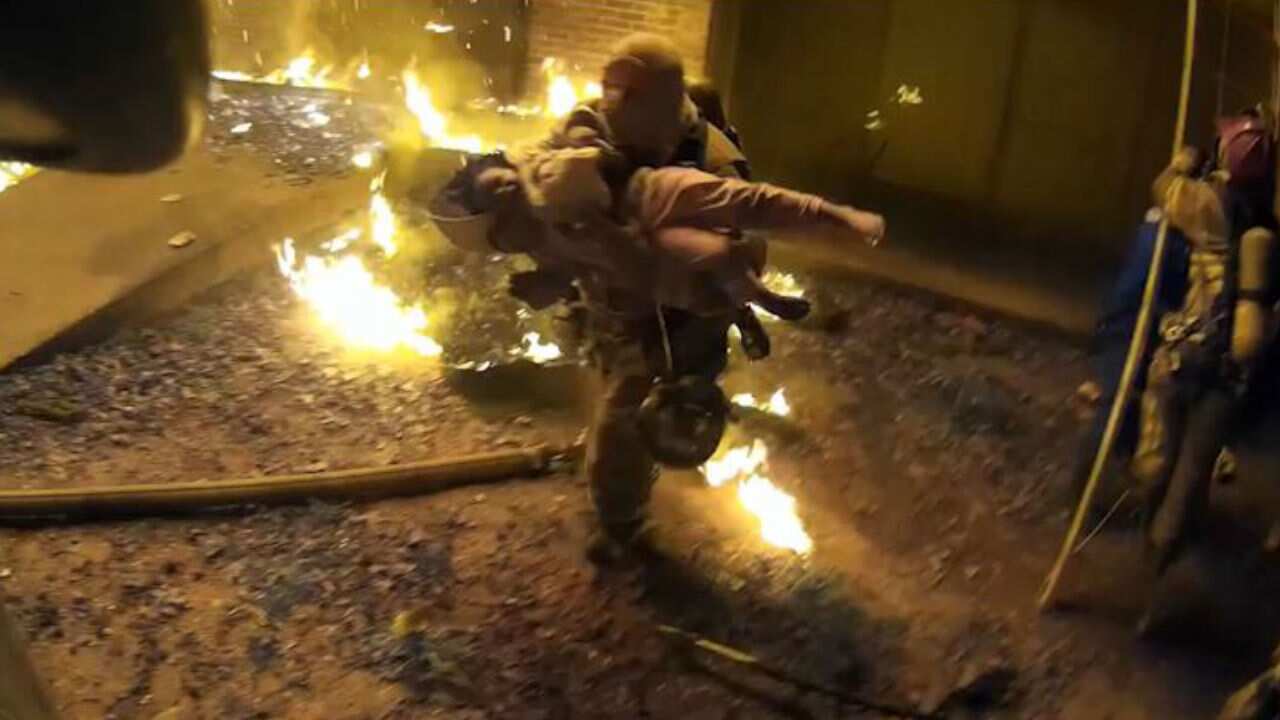 Captain Scott Stroup catches a young child thrown to safety.