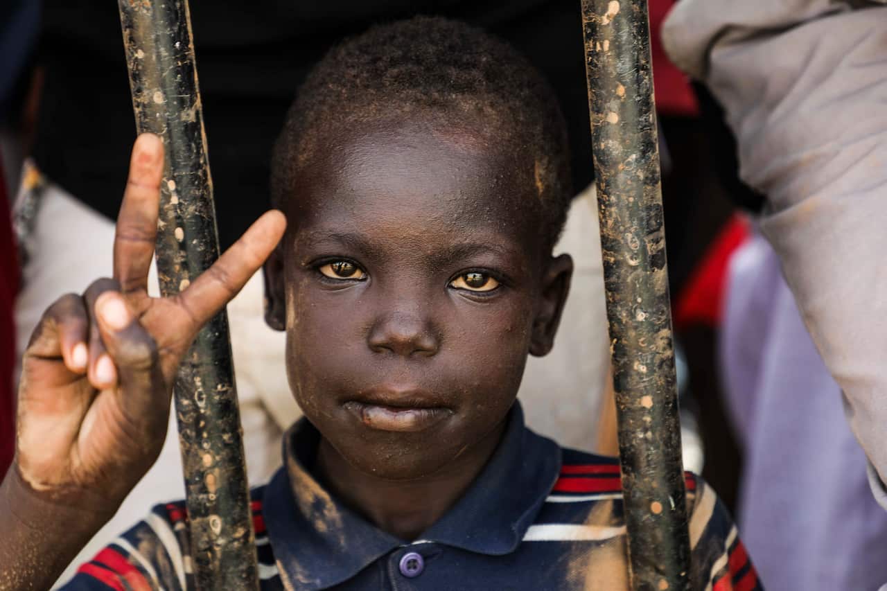 A Sudanese boy flashes the victory sign during the protest. 