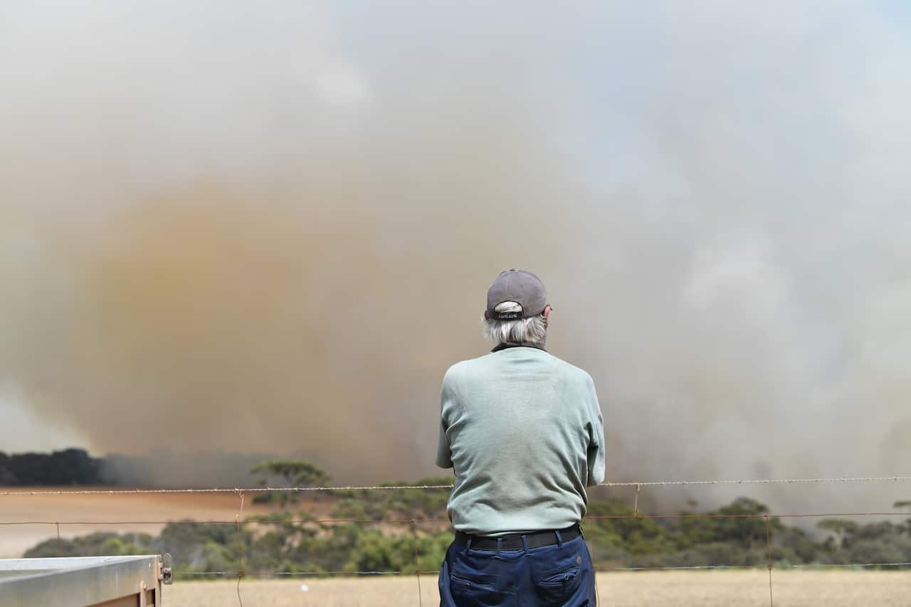John Stanton looks on as bushfires sweep through Stokes Bay on Kangaroo Island.