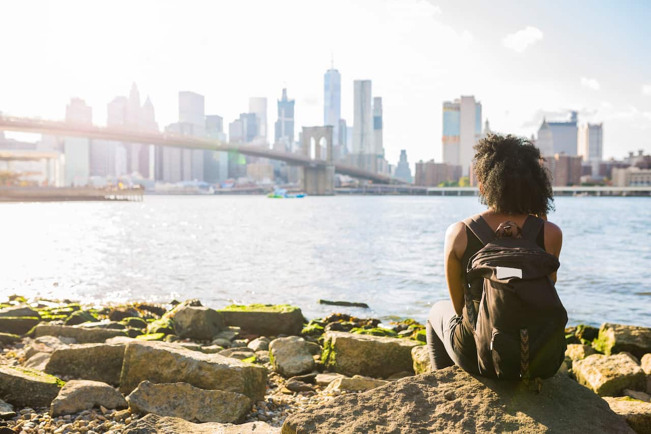 USA, New York City, Brooklyn, woman sitting at the waterfront