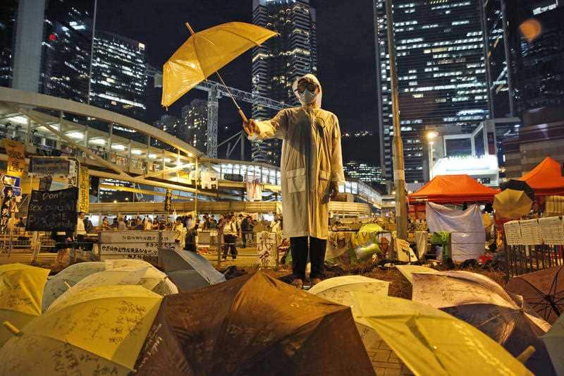 In a 2014 photo a protester holds an umbrella during a performance on a main road in the occupied areas outside government HQ in Hong Kong's Admiralty.