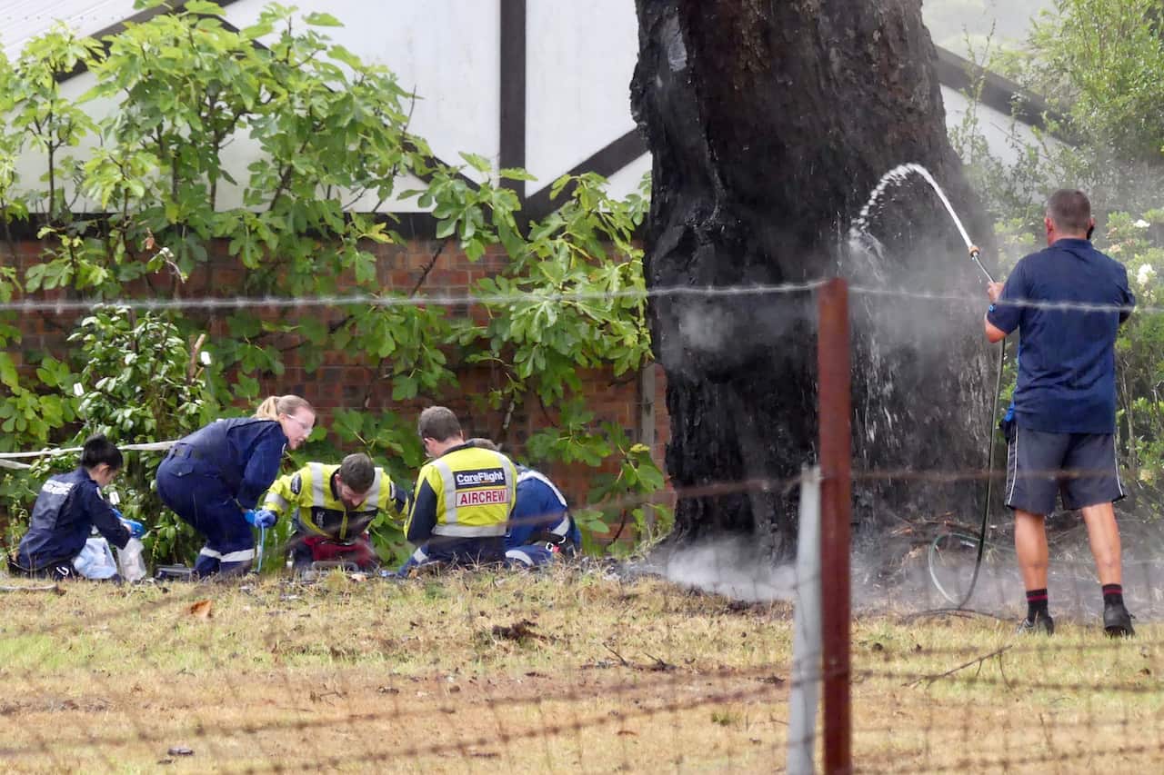 Paramedics administer CPR to a woman who was struck by lightning standing underneath a tree in her Arcadia residence.