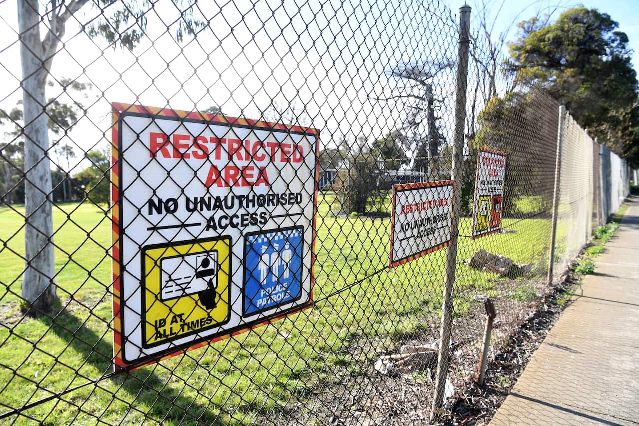 Signage is seen along the fence of the Melbourne Immigration Transit Accommodation complex in Broadmeadows, Melbourne.