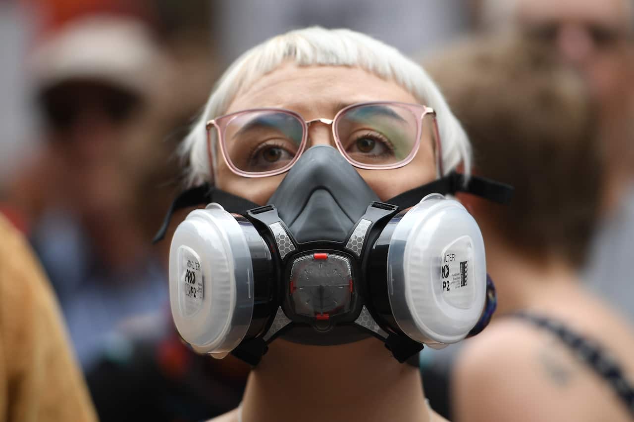 A woman wears a filter mask during the “NSW is Burning, Sydney is Choking" climate rally in Sydney’s inner city.