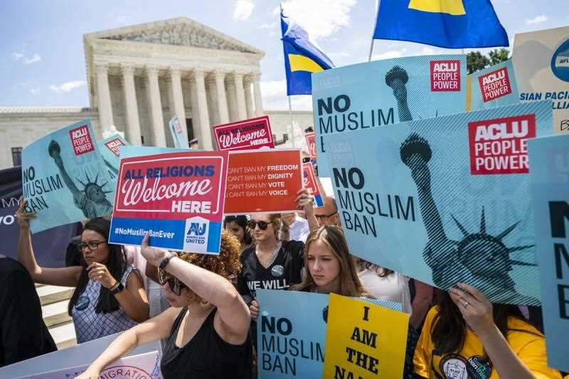 Protesters gather outside the Supreme Court to protest the judge's ruling to uphold President Trump's travel ban in Washington