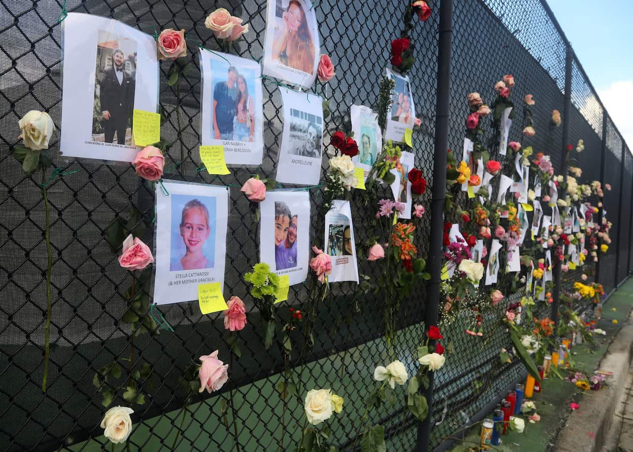 A makeshift memorial shows some of the people missing from the 12-story oceanfront Champlain Towers South Condo.