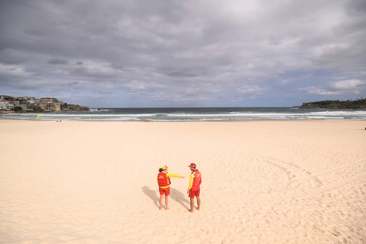 Surf lifesavers on an empty Bondi Beach following its closure in Sydney, Saturday, March 21, 2020.