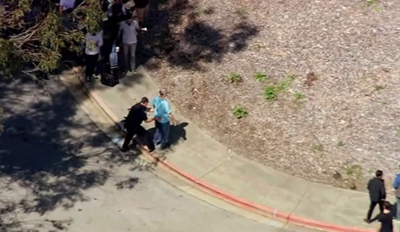 This image taken from video from KGO-TV shows a person is searched as police respond to reports of a shooting at YouTube headquarters