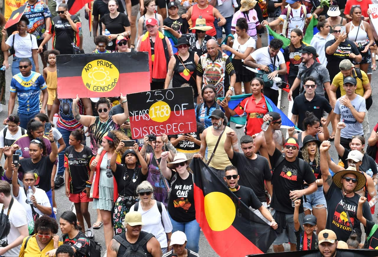 Protestors are seen crossing the Victoria Bridge during the Invasion Day rally in Brisbane.
