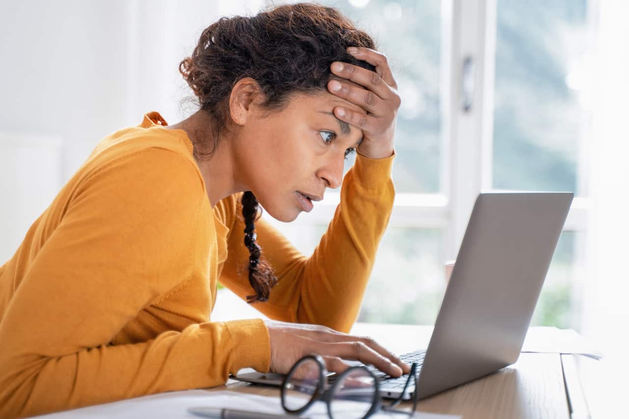 Young woman feeling stressed while looking at computer