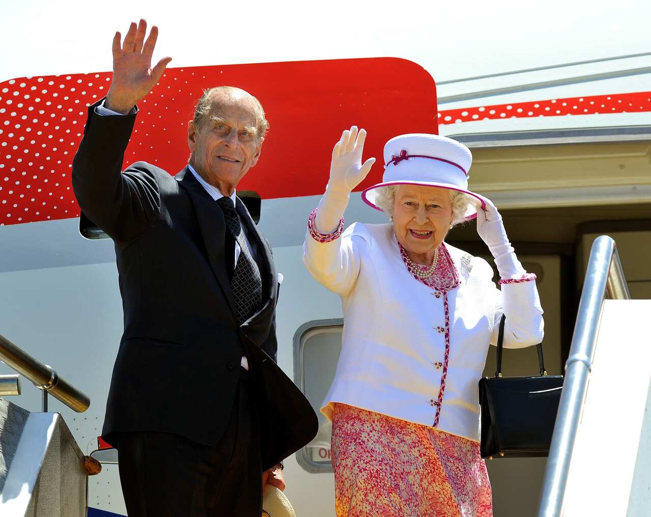 The Queen (right) and Prince Philip (left) stand at the top of aeroplane steps and wave goodbye at Perth Airport at end of 16th Royal Tour to Australia in 2011.