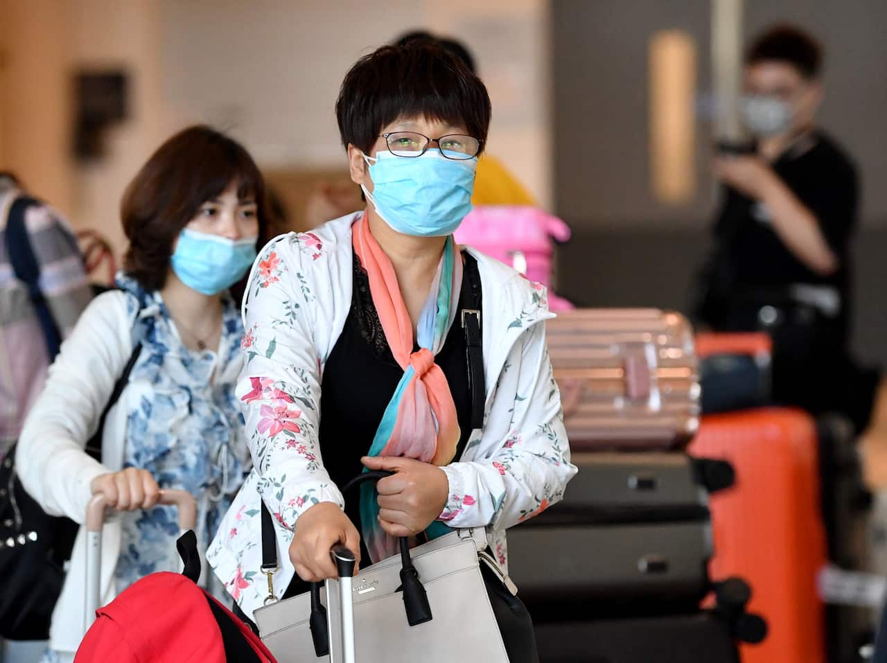 People wearing protective face masks at Brisbane International on Wednesday.