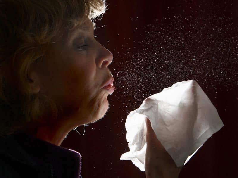 A woman sneezing.