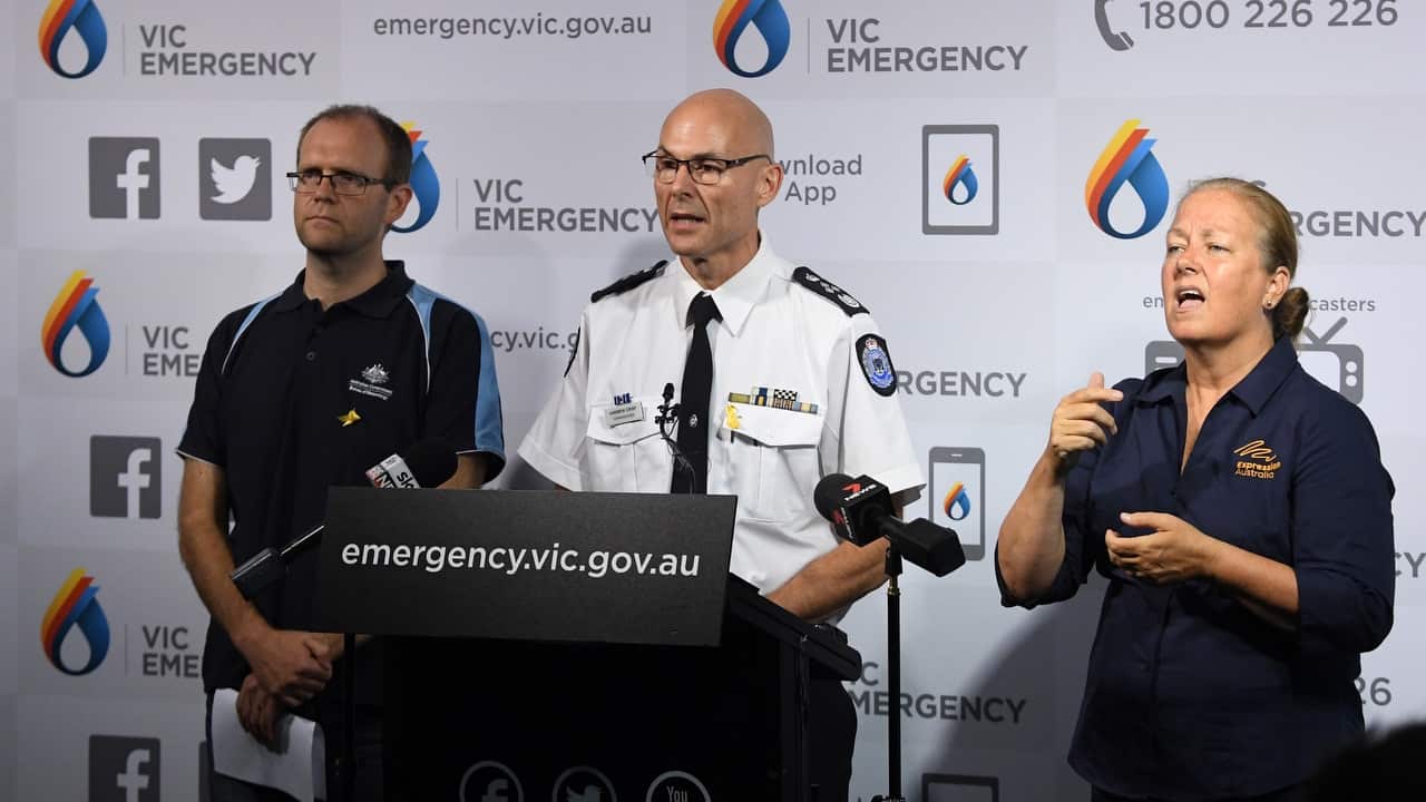 Andrew Crisp, Emergency Management Commissioner (centre) addresses the media at the State Control Centre, Melbourne.