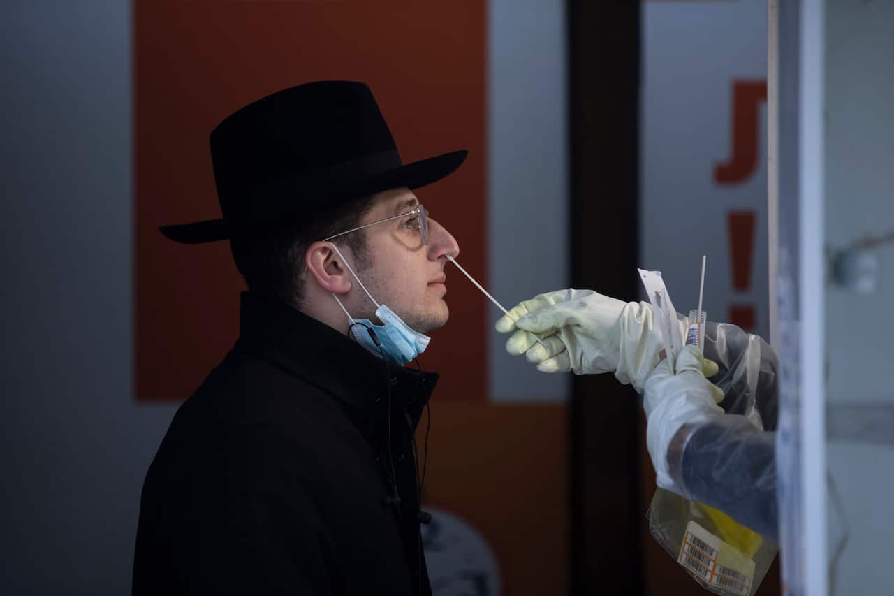 An Israeli health worker tests an unvaccinated ultra-Orthodox Jewish seminary student for COVID-19 at a coronavirus testing centre in Jerusalem.