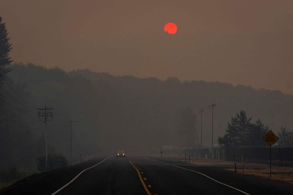 Tinted orange by wildfire smoke from Oregon and southern Washington, the sun sets behind a hill on September 9.