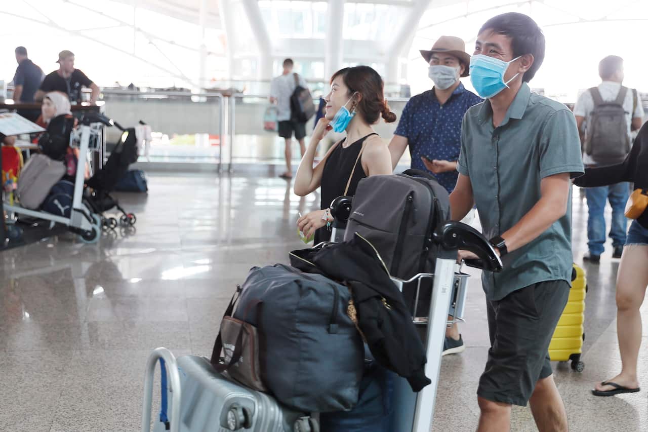 Passengers wearing masks at Ngurah Rai International Airport in Bali. Millions of Chinese tourists flock to Bali each year. 
