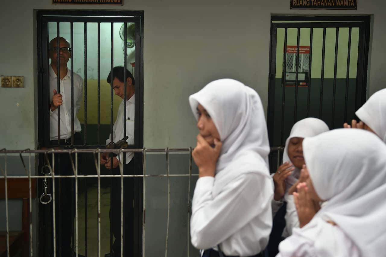 Neil Bantleman, left, a guidance counselor, and Ferdinand Tjiong, second left, a teaching assistant, in a holding cell in Jakarta in 2015.